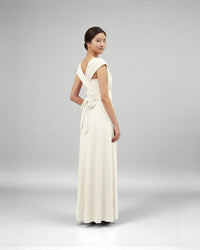 BridesmaidsJP ivory infinity dress with a tie waist, worn by a model with her hair in a bun.