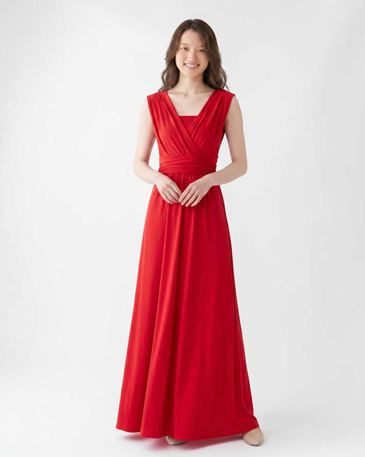 BridesmaidsJP red infinity dress with a V-neckline and flowing A-line skirt, worn by a smiling woman against a white background.