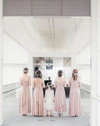 BridesmaidsJP smokey pink infinity dresses with versatile styling options, worn by women and a flower girl in a modern hallway.