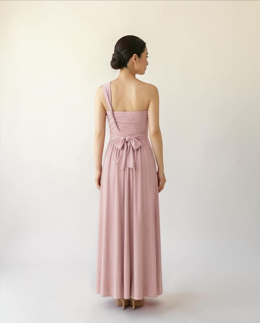 BridesmaidsJP smokey pink infinity dress with one-shoulder strap and bow detail at the back, floor-length.