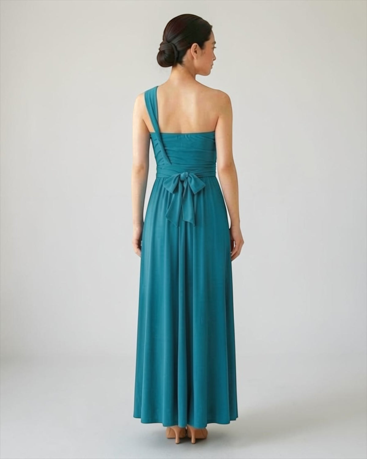 BridesmaidsJP turquoise long infinity dress with a one-shoulder design and a bow tie at the back, made of jersey material.